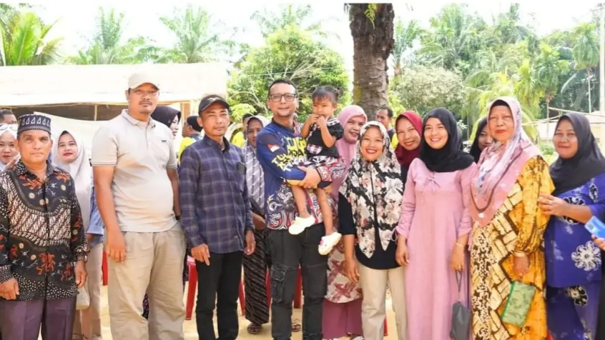 Bupati Labusel Fery Sahputra mengendong anak salah seorang warga saat melakukan kegiatan jemput aspirasi ke salah satu desa.(KHAIRUDDIN/SUMUT POS)