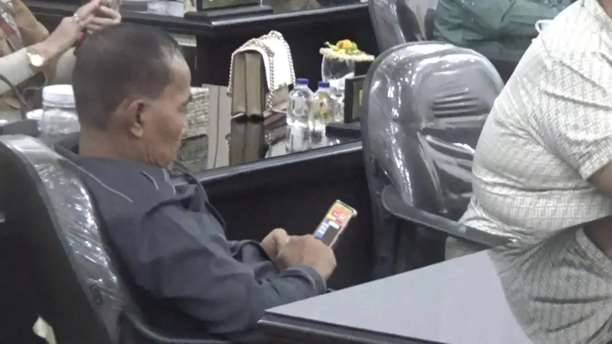 BERMAIN GAME:  Anggota Dewan DPRD Sergai berinisial JS tertangkap kamera sedang bermain game di ponsel saat Rapat Paripurna berlangsung, Senin (13/4/2026).(ISTIMEWA/SUMUT POS)