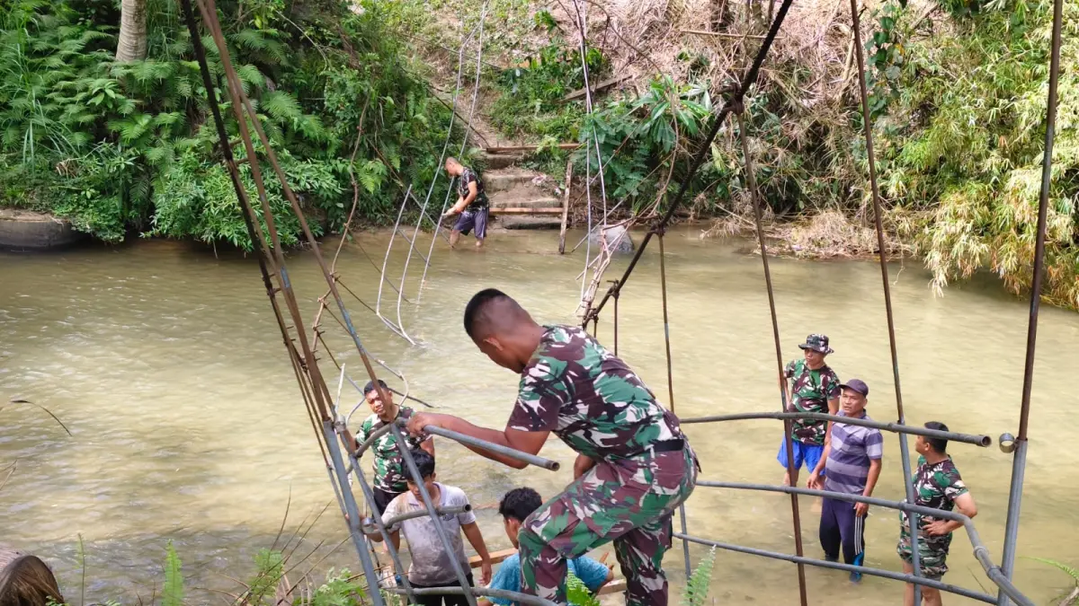 JEMBATAN: Prajurit TNI saat membangun jembatan gantung di Desa Parupuk Julu, Kecamatan Padang Bolak Julu, Kabupaten Paluta. (Dok: istimewa) 
