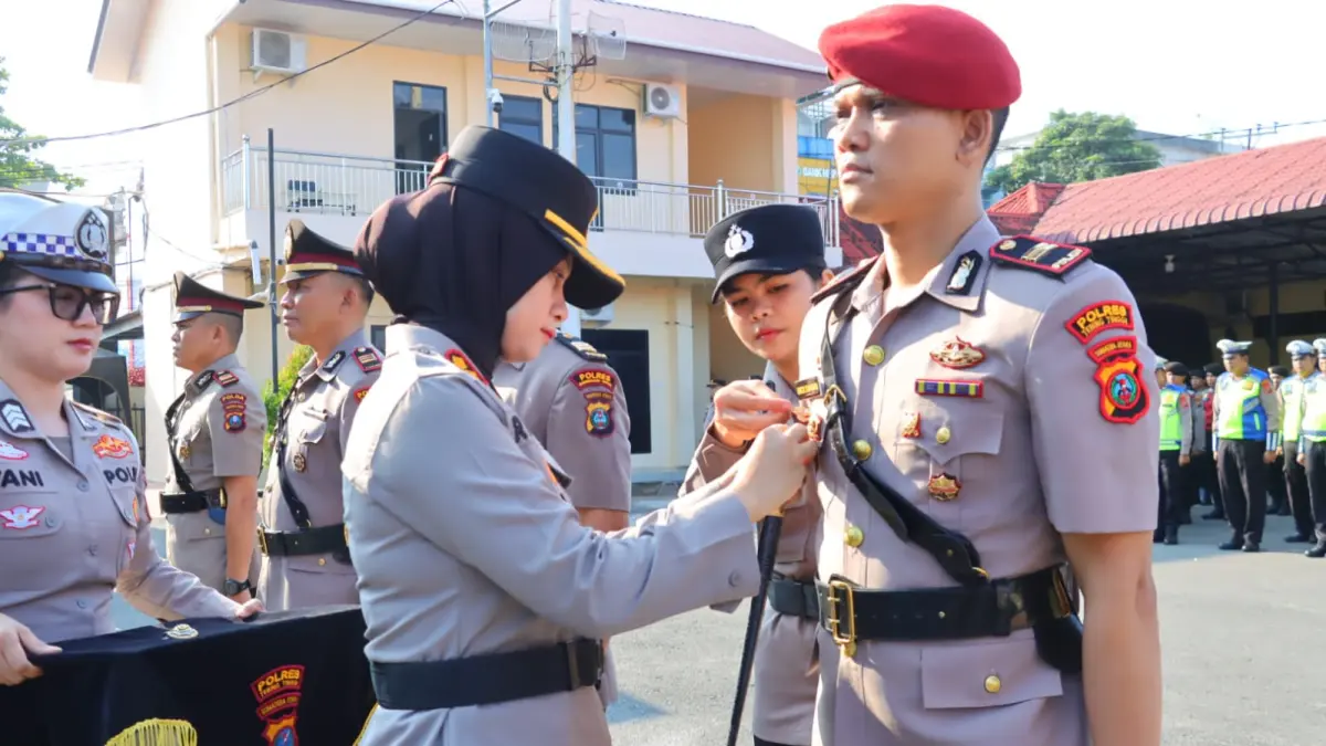 Kapolres Tebing Tinggi Rina Frillya, menyematkan tanda jabatan kepada personel dalam upacara serah terima jabatan. (Azan Purba /Sumut Pos)