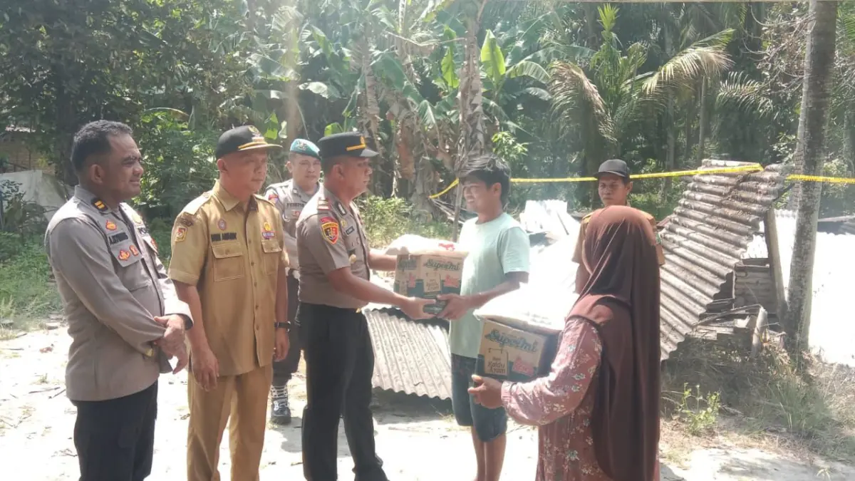 Kapolsek Teluk Mengkudu IPTU Halomoan Sirait menyerahkan bantuan sembako kepada korban kebakaran di Desa Bogak Besar sebagai bentuk kepedulian dan dukungan kemanusiaan. ( Fadly/ Sumut Pos )