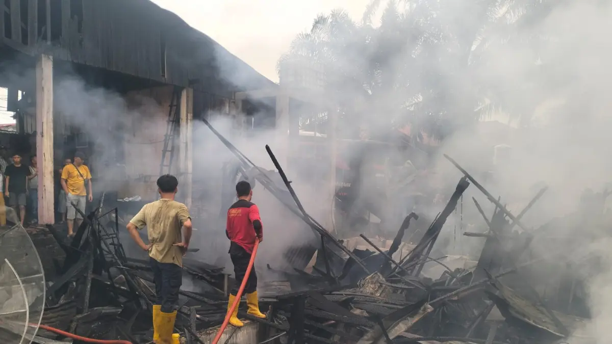 Petugas Damkar memadamkan api yang melahap rumah di komplek  pool bus PT Kota Pinang Baru Labusel. (ISTIMEWA/SUMUT POS)