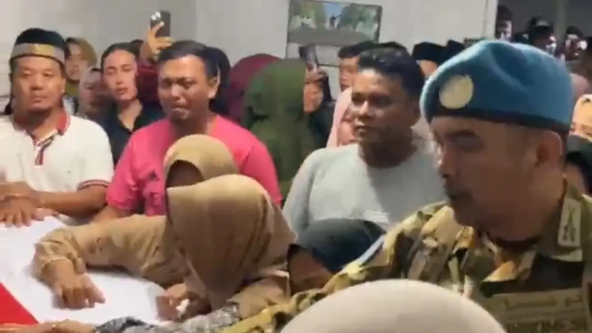 Suasana haru di rumah duka, keluarga dan isteri almarhum tak kuasa menahan tangis saat mengiringi kepergian almarhum. Seorang anggota TNI tampak menenangka di tengah kerumunan warga yang turut berbelasungkawa.( Fadly/ Sumut Pos )