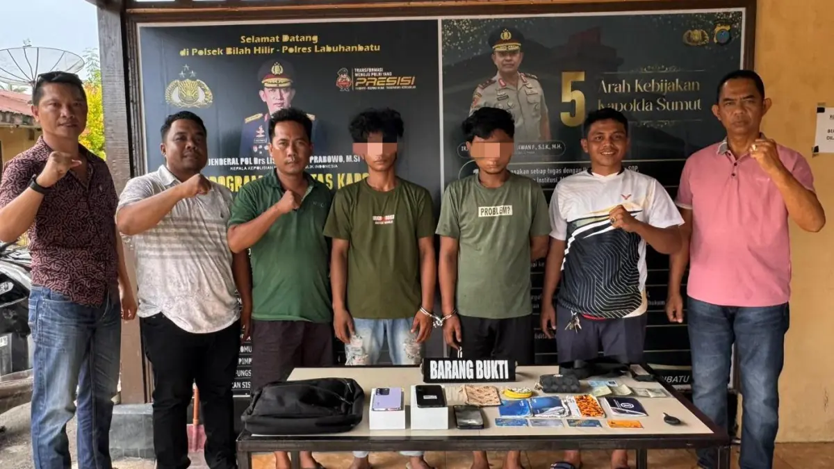 Tersangka MF dan IS terduga pelaku kejahatan di Bilah Hilir, Labuhanbatu diapit sejumlah personel Polri (Fajar/Sumut Pos)
