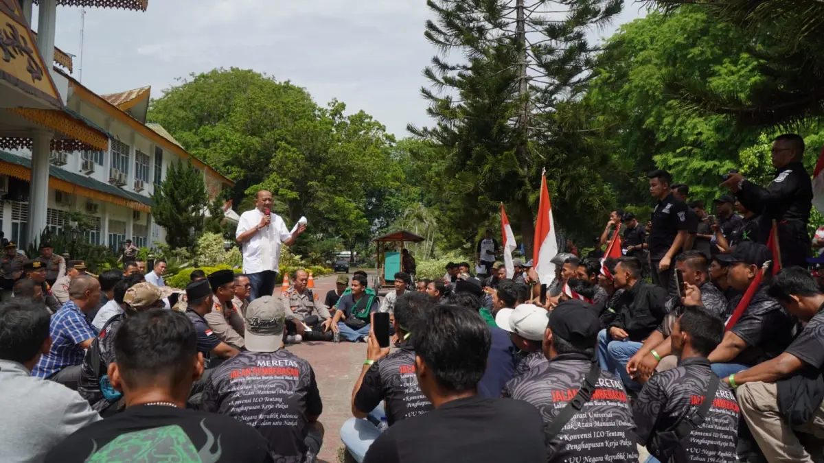 BURUH: Bupati Langkat, Syah Afandin (berdiri kiri) saat menerima massa aksi buruh di kantornya. (Dok: Diskominfo Langkat/Sumut Pos)

