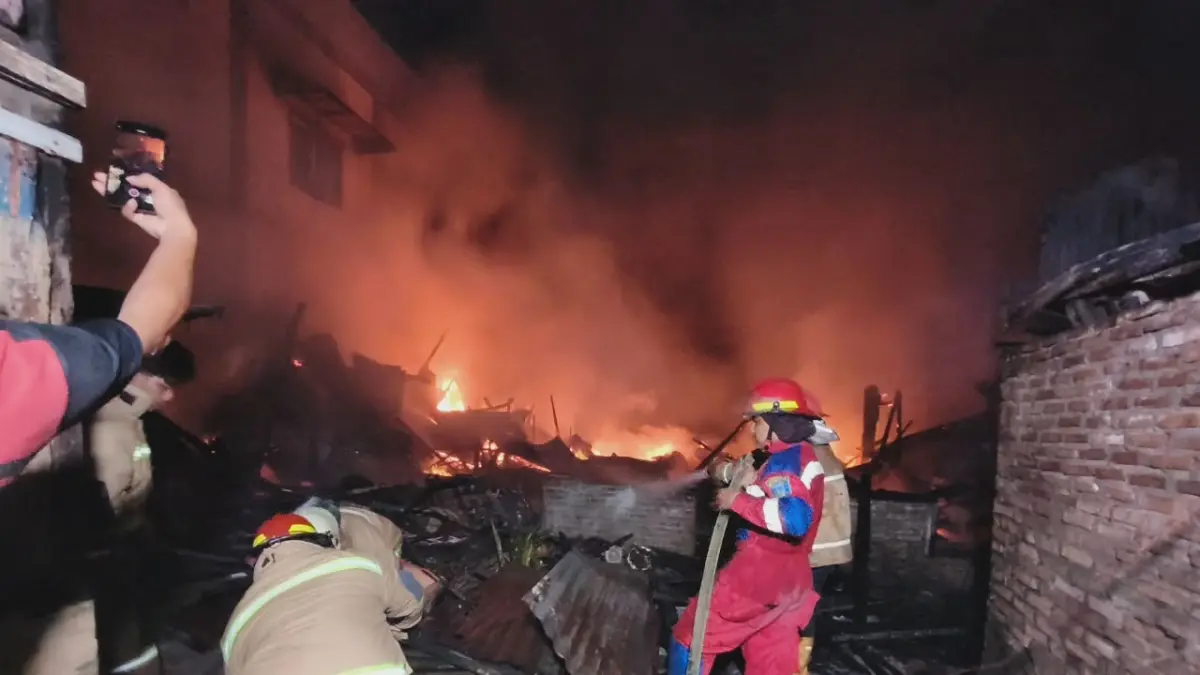 Tim Pemadam Kebakaran berjibaku memadamkan kobaran api di lokasi kejadian agar tidak merambat ke bangunan lain di sekitarnya, Minggu (3/5/2026). (Azan Purba / Sumut Pos)