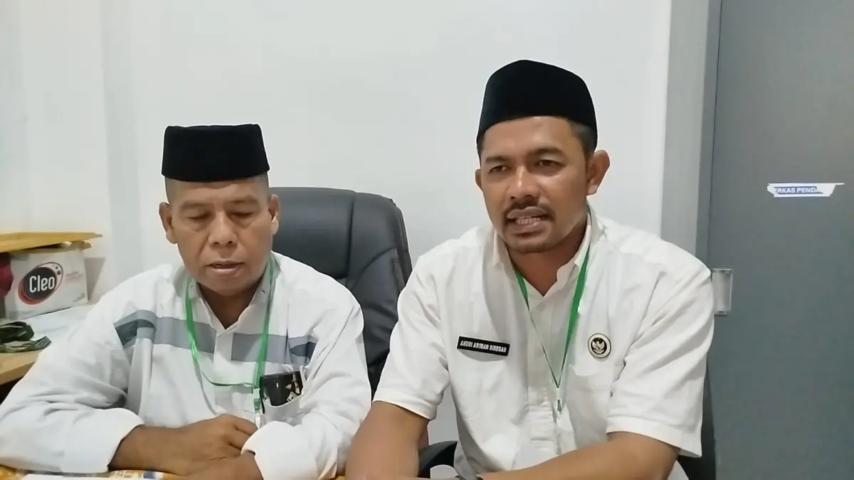 Kepala Kantor Kementerian Haji dan Umroh Labuhanbatu, Mahdan Munthe, didampingi staf Andri A Siregar, Senin (4/5/2026) di ruang kerjanya.
