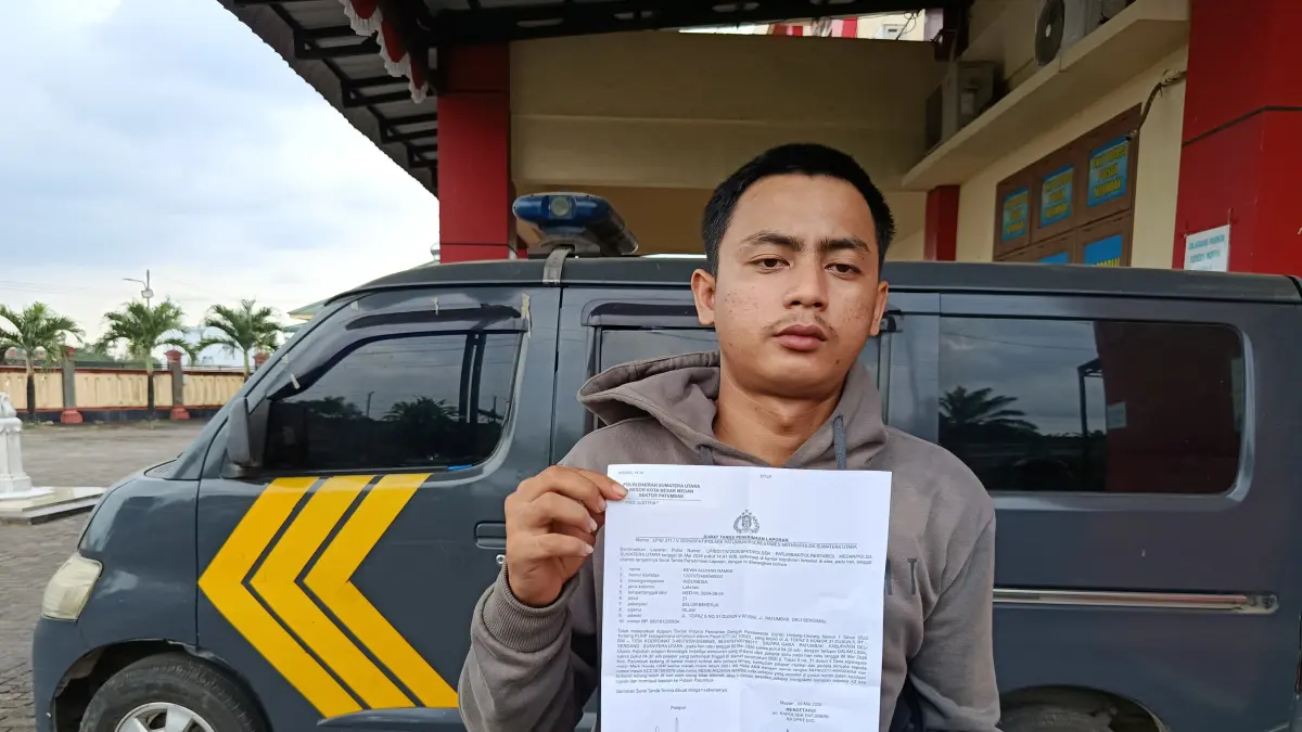 LAPORAN: Korban Kevin Adzhan Rambe (22) saat menunjukkan surat laporannya ke Mapolsek Patumbak. (Dok: istimewa)

