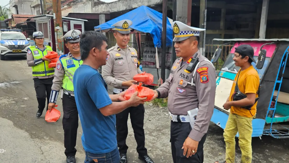 BAROKAH: Kasat Lantas Polres Sergai, Gokma W. Silitonga membagikan nasi kota Jumat Barokah kepada warga pengguna jalan. (Istimewa)