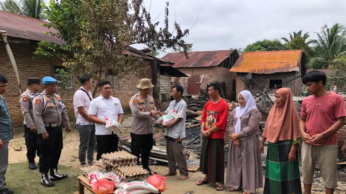 Kapolsek AKP Gunawan Sinurat saat menyerahkan bantuan sosial kepada warga yang tertimpa musibah kebakaran di desa Batu Tunggal. (Indra/Sumut Pos)