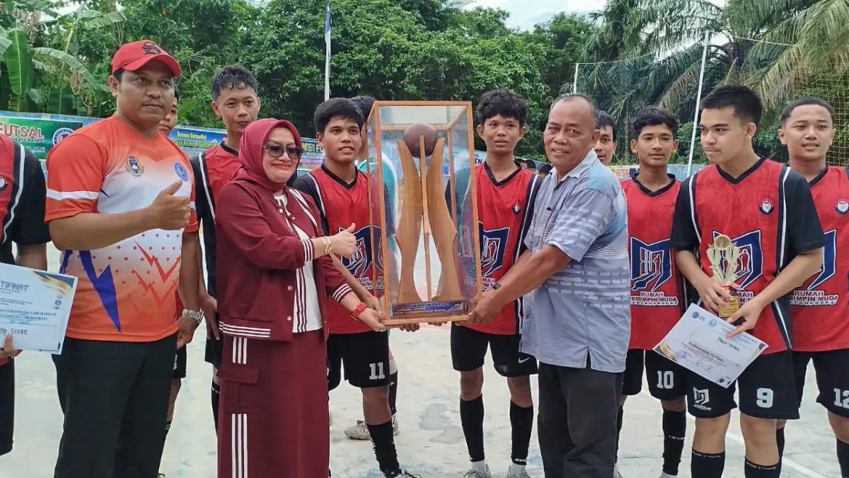 TROPI BERGILIR: Pengurus Yayasan Universitas Labuhanbatu menyerahkan tropi bergilir kepada Tim Futsal SMAN 2 Ranut yang berhasil meraih juara di Turnamen Futsal SLTA se Labuhanbatu Raya.(Fajar/Sumut Pos)