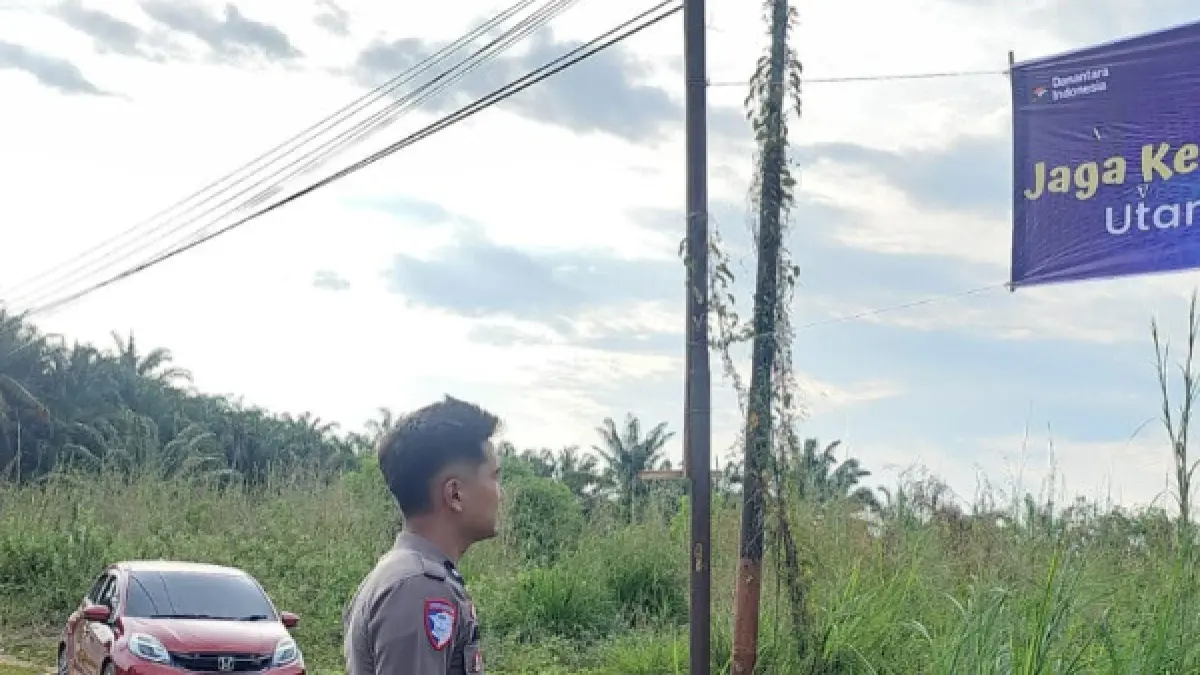 Personel Satlantas Polres Labusel melakukan pemasangan spanduk imbauan keselamatan pengendara. (Khairuddin/Sumut Pos)