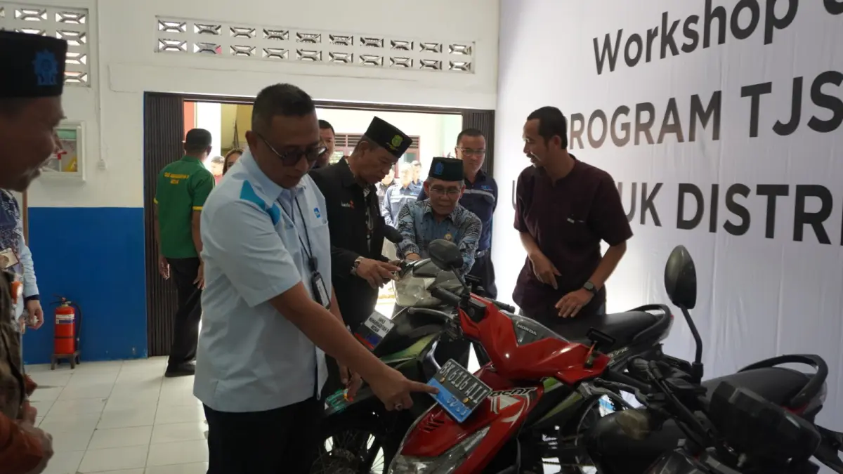MOTOR LISTRIK: Manager Komunikasi dan TJSL PLN UID Sumut bersama Kepala Sekolah SMK Muhammadiyah 9 Medan saat melihat langsung hasil bengkel konversi motor listrik. (Dok PLN UID Sumut/Sumut Pos)