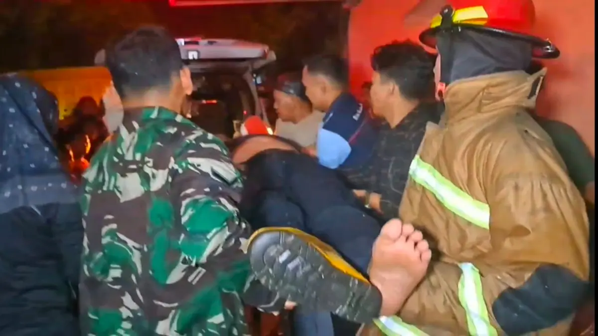 
Petugas pemadam kebakaran dievakuasi usai cidera saat  memadamkan api yang melalap rumah warga di kawasan padat penduduk di gang coklat jalan cemara Tebingtinggi, Kamis (21/05/2026) malam.  (Azan Purba / Sumut Pos)
