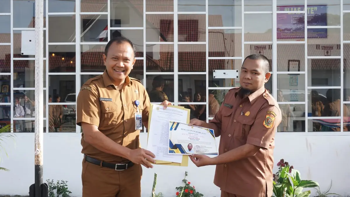 Dedy Situmorang sewaktu menjabat Kepala Dinas Kependudukan dan Catatan Sipil Dairi memberikan apresiasi penghargaan kepada stafnya. (Disdukcatpil Dairi).