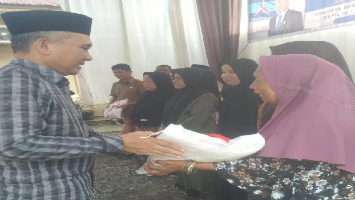 H. Lumba Munthe saat menyerahkan bingkisan kepada warga, usai kegiatan reses. (Indra/Sumut Pos