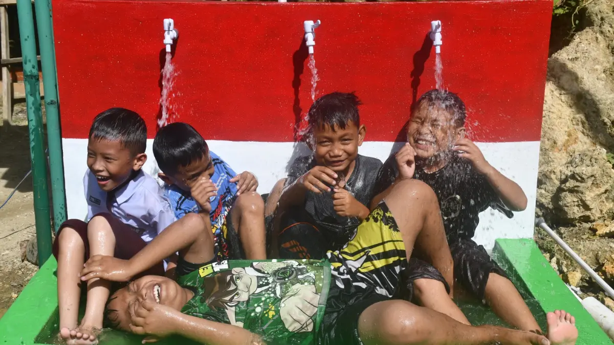 AIR BERSIH: Anak anak Saombo, Gunungsitoli saat menikmati air bersih bantuan Presiden RI Prabowo Subianto. (Dok: Pendam I/BB)

