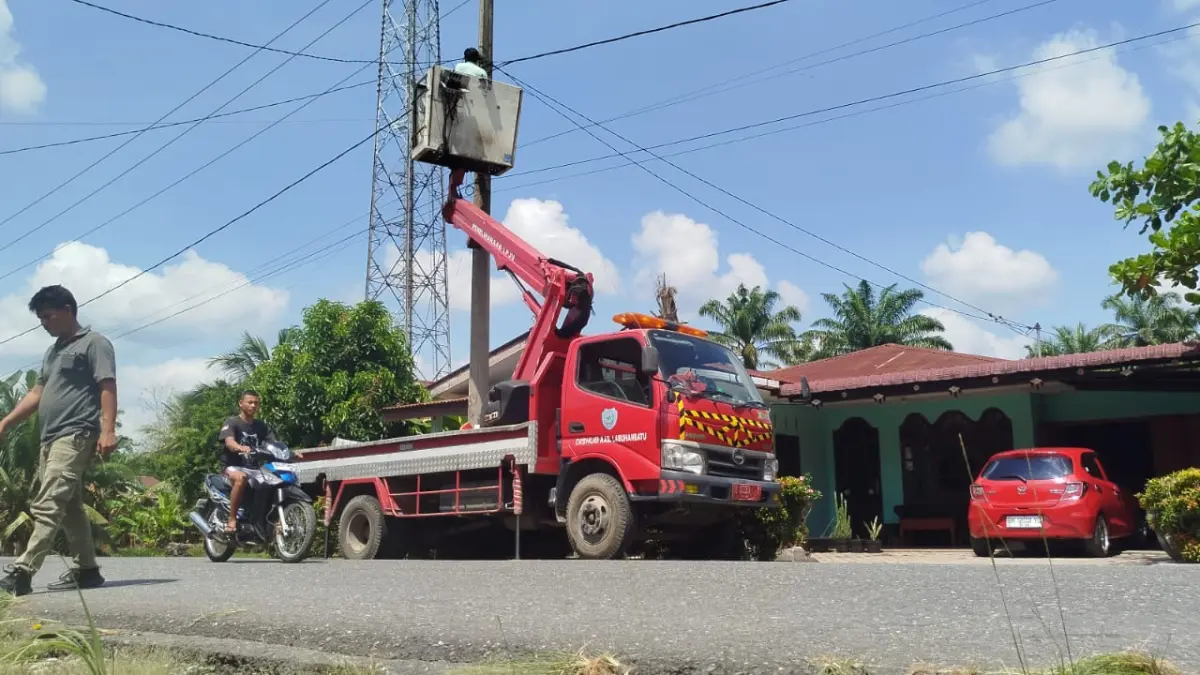 Tim Pemeliharaan LPJU Dishub Labuhanbatu memperbaiki instalasi dan mengganti bohlam lampu penerangan jalan yang rusak di Lingkungan Sidodadi PNK. (fajar/Sumut Pos)