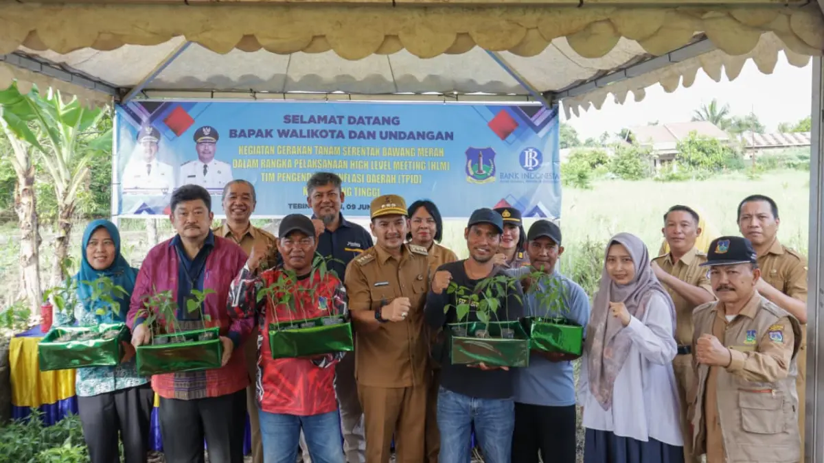 Wali Kota Tebing Tinggi H. Iman Irdian Saragih bersama perwakilan Bank Indonesia, unsur Forkopimda, kepala OPD, dan kelompok tani menunjukkan bibit cabai merah usai penyerahan bantuan stimulan pada kegiatan Gerakan Tanam Serentak Bawang Merah yang dirangkaikan dengan High Level Meeting (HLM) TPID di Kelurahan Mekar Sentosa, Kecamatan Rambutan, Selasa  sore (09/06/2026). (Azan Purba / Sumut Pos)