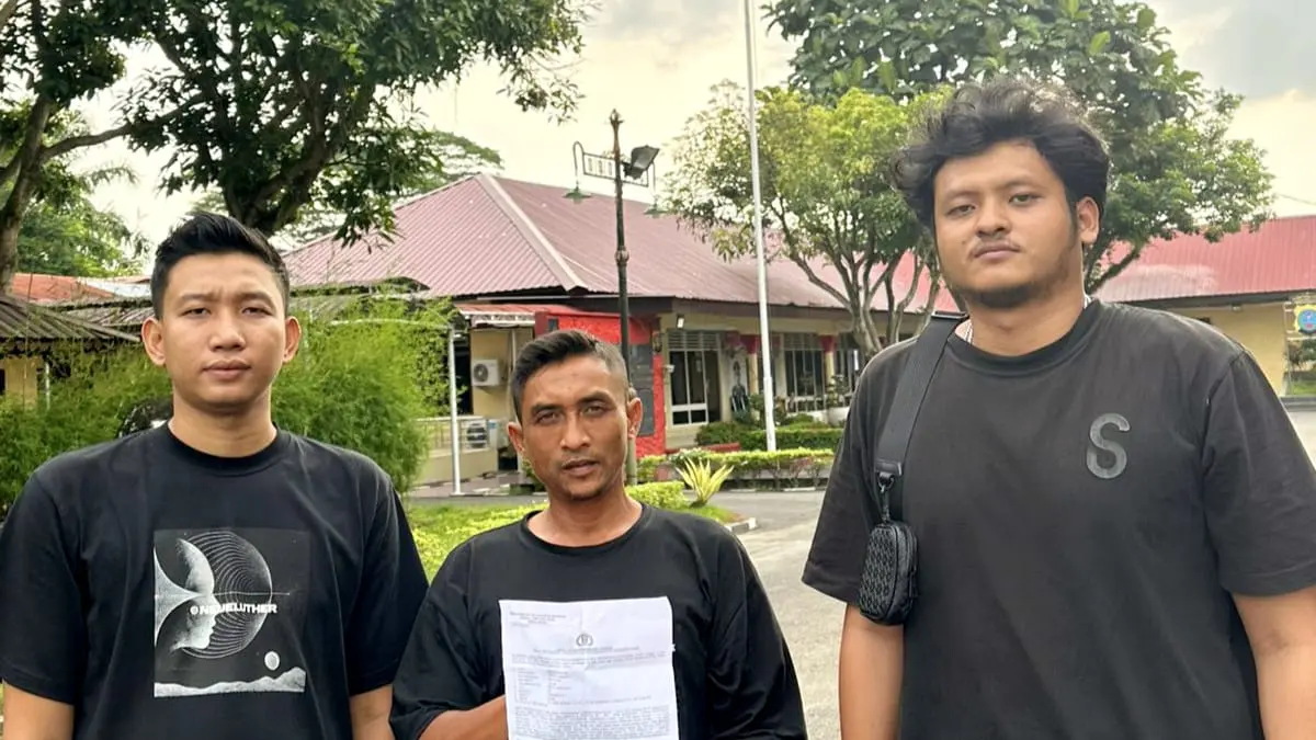 
Korban Dedi (tengah) menunjukkan bukti laporan polisi atas dugaan penganiayaan dengan terlapor Koordinator Jukir berinisial SD dan IB. (Foto dari massa aksi/Sumut Pos)