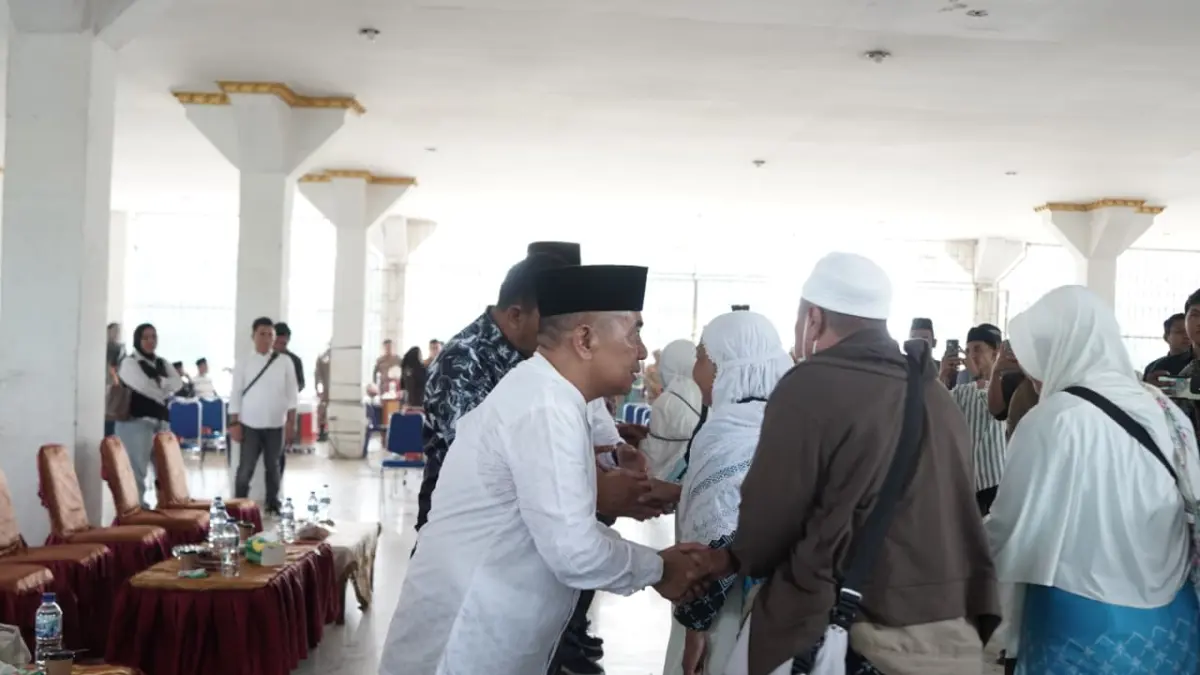 HAJI: Wakil Bupati Labusel, Syahdian Purba bersalaman dengan jamaah haji yang baru tiba. (Dok: Diskominfo Labusel)