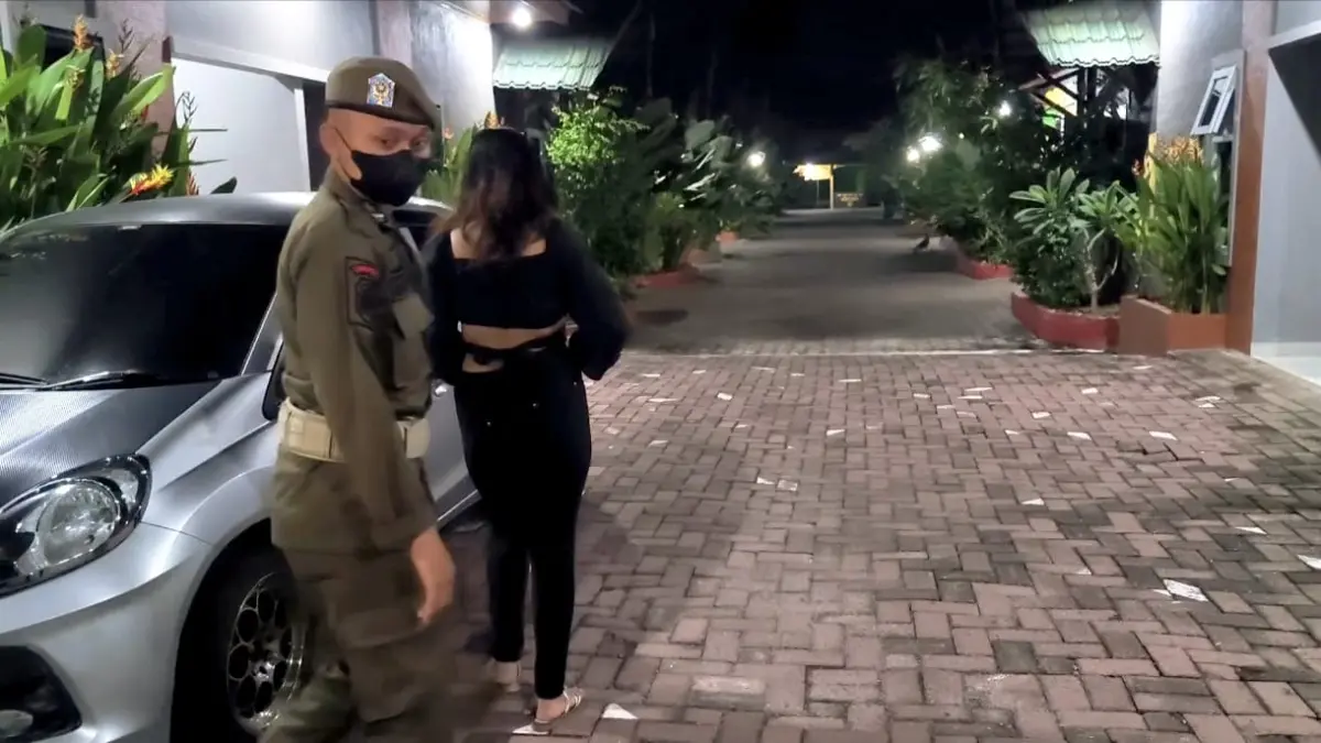 
Satpol PP saat membawa seorang wanita dari kamar hotel untuk dilakukan tes urine. (Teddy Akbari/Sumut Pos)