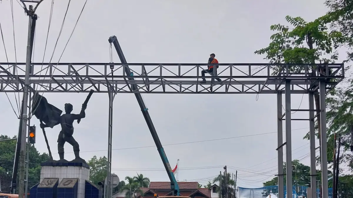 Sejumlah pekerja sedang memasang gapura yang terbuat dari besi baja di Jalan Simpang Tanjung Garbus, Lubukpakam. Bangunan gapura baru tersebut akan mempercantik layout komplek perkantoran kantor Bupati Deliserdang. (Batara/Sumut Pos)