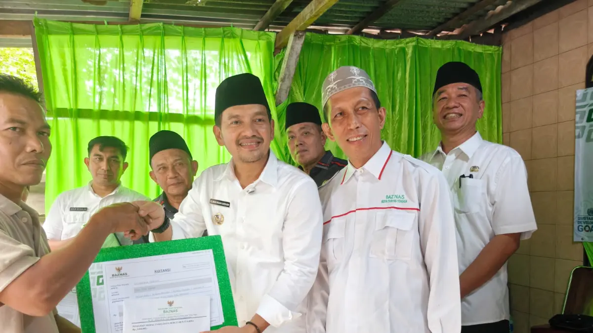 Wali Kota Tebing Tinggi Iman Irdian Saragih, didampingi Sedako Tebing Tinggi Erwin Suheri Damanik serta Ketua BAZNAS Kota Tebing Tinggi, Khuzamri Amar, menyerahkan secara simbolis bantuan modal usaha dana bergulir kepada salah seorang pelaku UMKM  di Kelurahan Brohol,  (24/6/2026).  (Azan Purba / Sumut Pos)