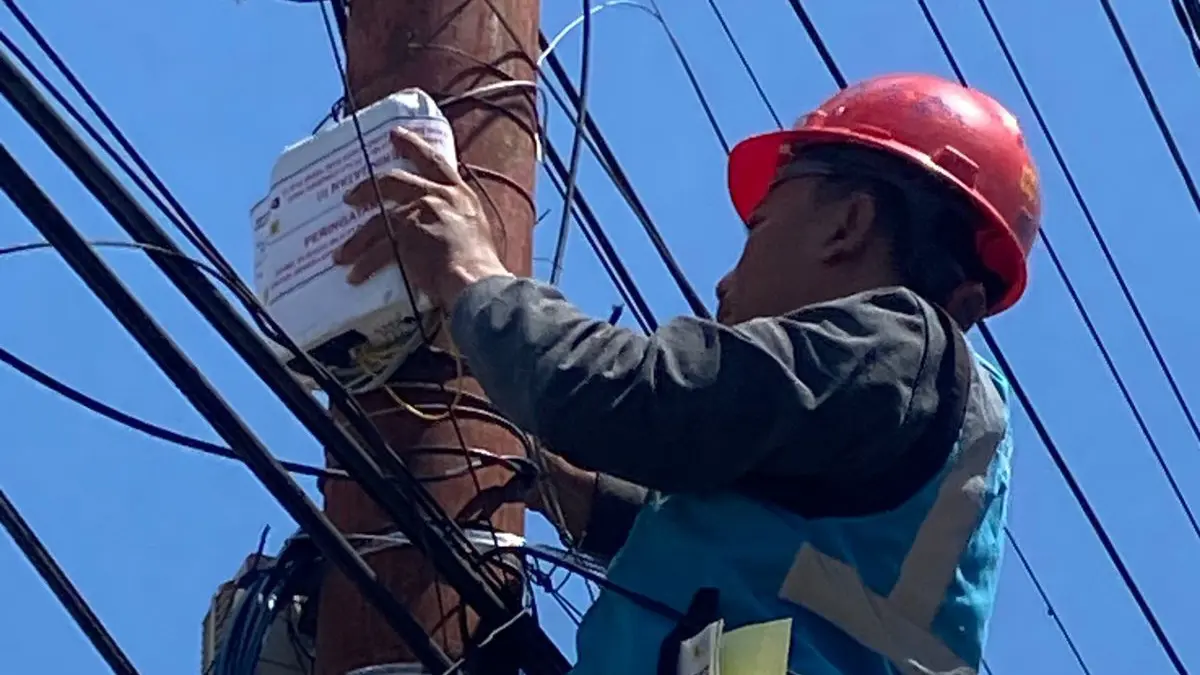 BERSIH: Petugas ICON Plus saat membersihkan kabel tiang listrik PLN dari kabel provider yang menumpang secara ilegal, di Kelurahan Pasar Sibuhuan, Kecamatan Barumun, Padang Lawas, Sabtu (27/6/2026). (Dok: Mitra Harahap/ Sumut Pos)