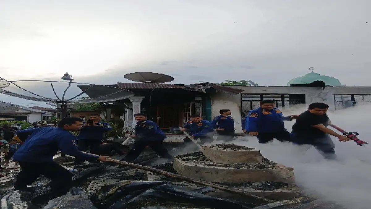  Petugas pemadam  kebakaran berusahan memadamkan api yang melahap tiga rumah akibat korsleting listrik.(Mitra Harahap/Sumut Pos)