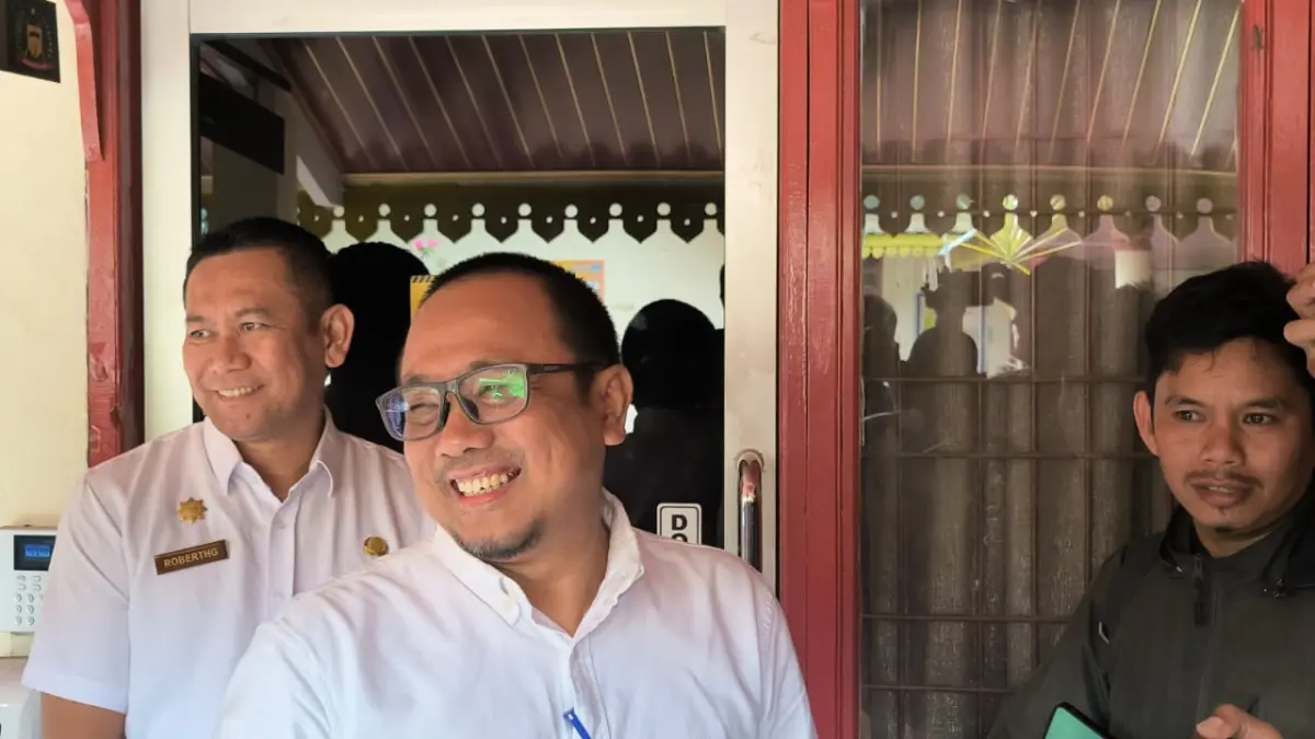 

Kadis Pendidikan Langkat, Ilhamsyah Bangun (kacamata) saat diwawancarai wartawan usai geledah. (Teddy Akbari/Sumut Pos)