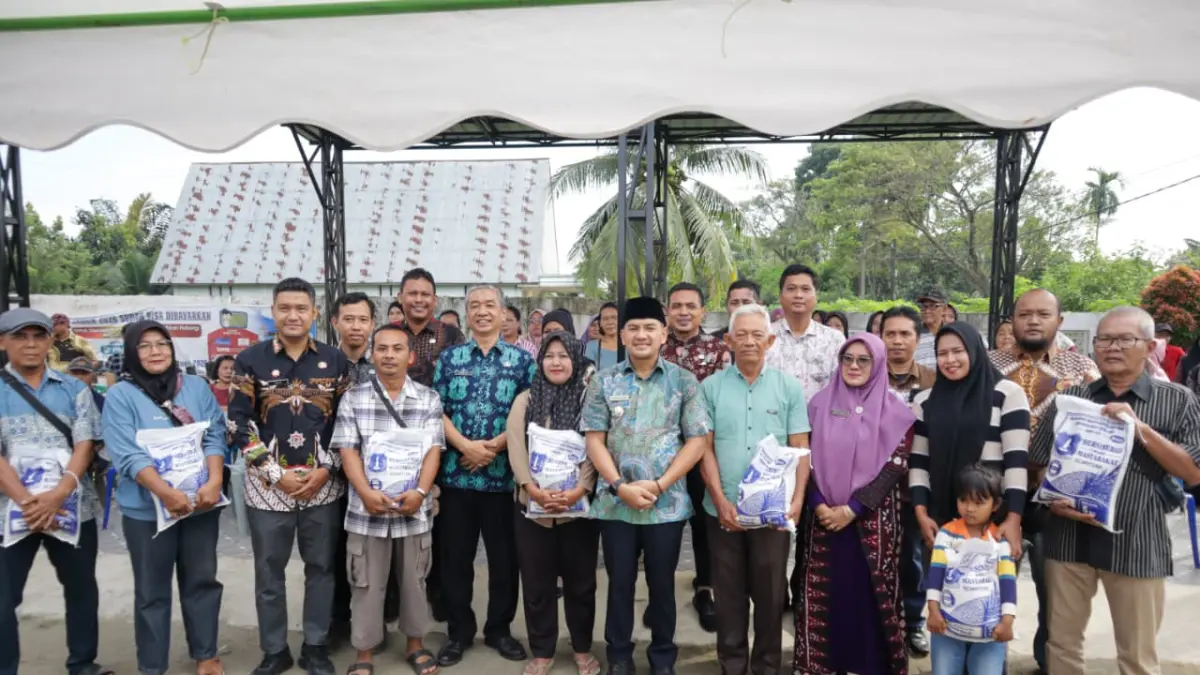 Wali Kota Tebing Tinggi H. Iman Irdian Saragih didampingi Sekda Erwin Suheri Damanik, Plt. Kepala Dinas Sosial Tigahara Hasibuan, serta camat dan lurah berfoto bersama warga usai meninjau penyaluran bantuan beras premium tahap pertama kepada keluarga kurang mampu di Kelurahan Pinang Mancung dan Kelurahan Tanjung Marulak, Jumat (10/7/2026). (Azan Purba/Sumut Pos)