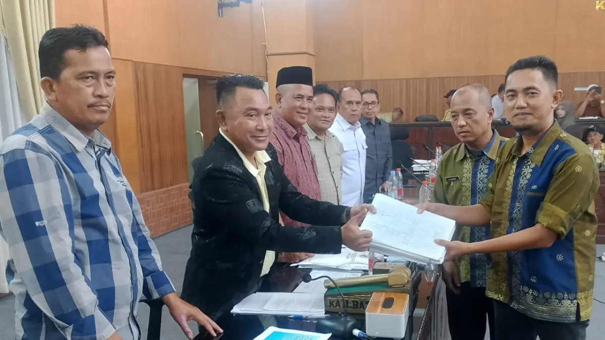 Kabid Perkebunan Distanbun Batubara , Ananda, saat serahkan dokumen informasi HGU Perusahaan Perkebunan di Batubara  kepada Ketua Pansus Plasma,.Ismar  Komri, saat rapat pansus plasma, Kamis(16/7/2026) di ruang Paripurna DPRD Batubara. ( Liberti H Haloho/Sumut Pos)