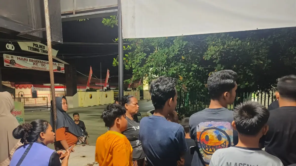  Sejumlah warga Lingkungan I dan II, Kelurahan Mandailing, berkumpul di depan Mapolres Tebingtinggi, Senin (20/7/2026) malam, mendengarkan penjelasan Kanit Tipidter Polres Tebingtinggi Ipda N.J. Silalahi terkait pengejaran terduga pelaku pencurian. (Azan Purba/Sumut Pos)