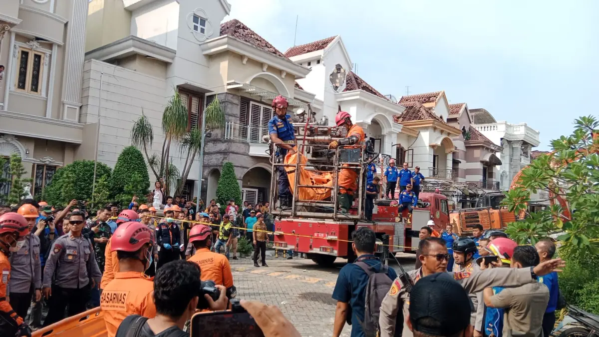 GABUNGAN: Petugas gabungan menurunkan korban kedua meninggal dari lantai dua rumah menggunakan crane damkar di lokasi ledakan Grand Polonia Medan, Selasa (21/7/2026). (Dok: Gusman/Sumut Pos)