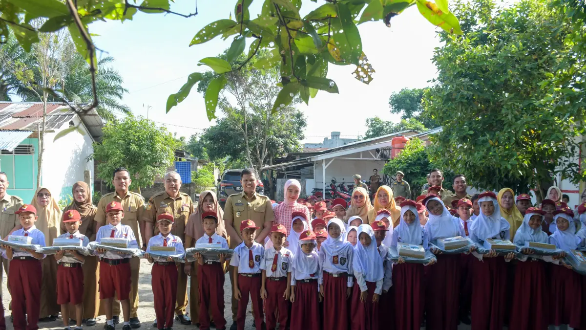 Wabup Sergai Adlin Tambunan saat serahkan bantuan kepada siswa/siswi di Perbaungan. ( Fadly/Sumut Pos)