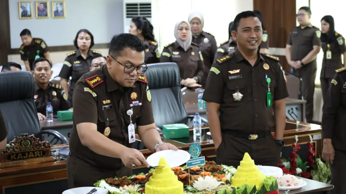 Kajari Deliserdang, Sapta Putra didampingi Kasi Intelijen Kejari Deliserdang, Roby Syahputra saat memotong nasi tumpeng. (Batara/Sumut Pos)