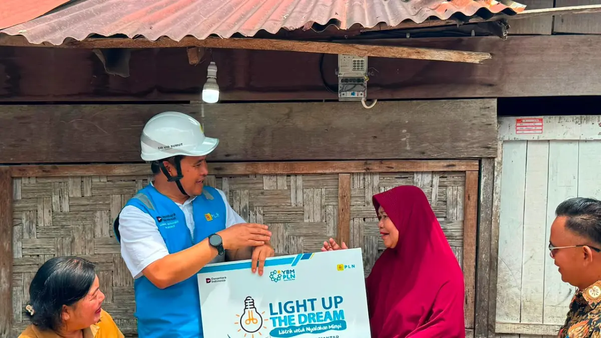 PENERIMA MANFAAT:  General Manager PLN UID Sumatera Utara Mundhakir menyalakan listrik gratis kepada salah seorang penerima manfaat melalui Program Light Up The Dream (LUTD) dan Xtra Care. (Dok: PLN UID Sumut)