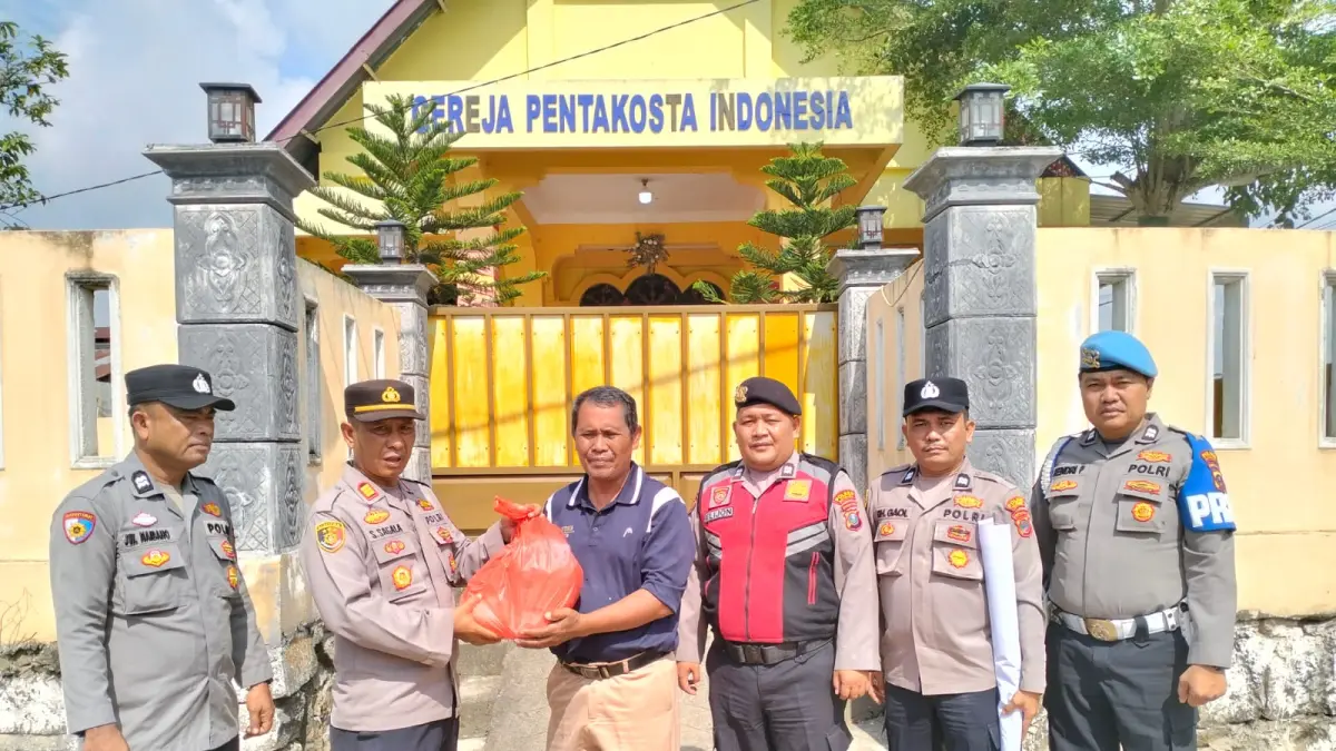 Kapolsek AKP Salomo Sagala, S.H saat  memberikan paket sembako kepada warga kurang mampu di Gereja Pentakosta Indonesia (GPI), Kelurahan Lima Puluh Kota, Minggu(26/7/2026). (Foto Liberti H Haloho/Sumut Pos)