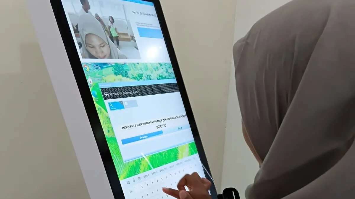 DAFTAR: Seorang peserta JKN mengambil nomor antrean poli atau pendaftaran di Anjungan Pendaftaran Mandiri (APM) atau kios pendaftaran mandiri (self-service kiosk) BJPS Kesehatan di RSU Murni Teguh Medan. Teknologi dan inovasi ini yang membuat salah satu JKN mendapat puji berbagai negara. (Laila Azizah/Sumut Pos).