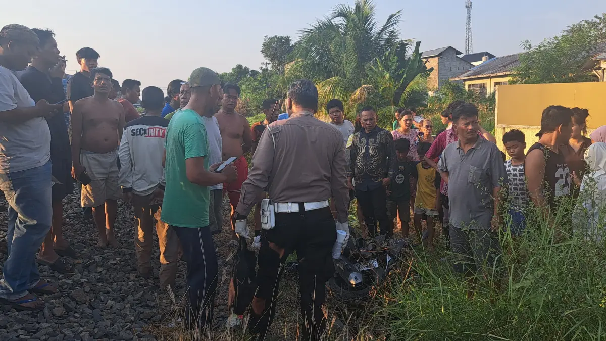 EVAKUASI: Petugas bersama warga mengevakuasi korban kecelakaan di perlintasan rel Jalan Lama, Kelurahan Sri Padang, Tebingtinggi, Sabtu (8/8) sore. (Dok: Azan Purba/Sumut Pos)