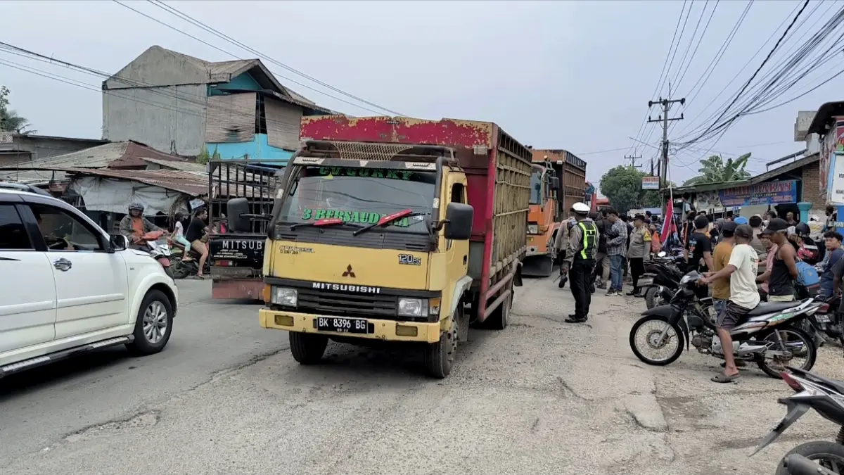 
Truk bermuatan kembali melintas usai masyarakat membubarkan diri dari aksi blokir jalan penghubung Kecamatan Binjai dengan Langkat. (Teddy Akbari/Sumut Pos)