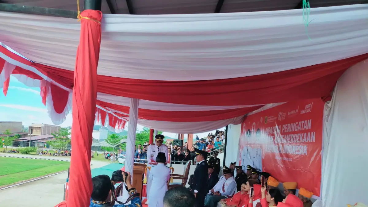 Bupati Dairi, Vickner Sinaga memberikan bendera merah putih kepada petugas paskibraka untuk dikibarkan pada peringatan HUTRI ke-81 di stadion Sitinjo, Senin (17/8/2026).(RUDY SITANGGANG/SUMUT POS)