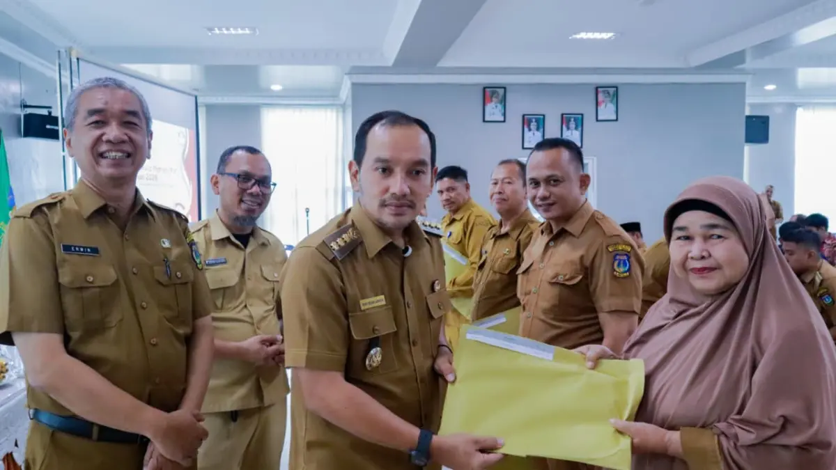  Wali Kota Tebingtinggi H. Iman Irdian Saragih menyerahkan SK Program Indonesia Pintar (PIP) secara simbolis kepada perwakilan kepala sekolah, didampingi Sekda Tebingtinggi Erwin Suheri Damanik dan jajaran terkait, dalam kegiatan penyerahan SK PIP kepada kepala SD dan SMP se-Kota Tebingtinggi di Aula Gedung Balai Kota, Selasa (18/8/2026). (Azan Purba/Sumut Pos)