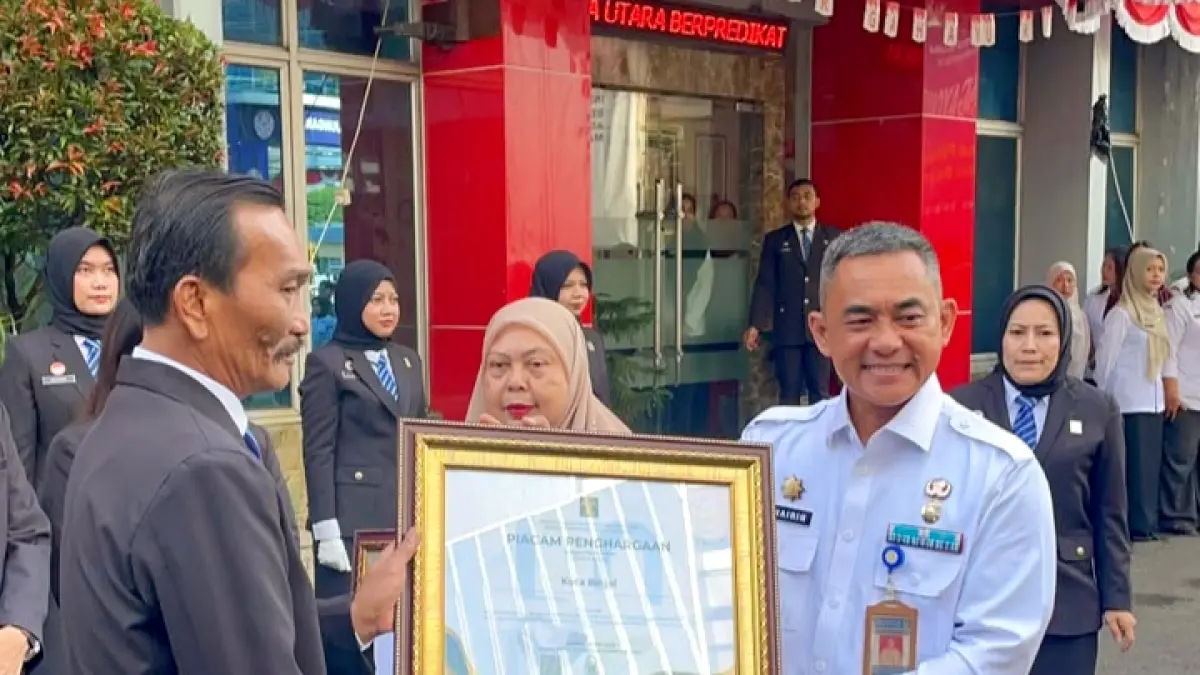 
Kakanwil Kemenkum Sumut, Ignatius Mangantar Tua Silalahi saat menyerahkan penghargaan kepada Sekda Binjai, Chairin Simanjuntak (kanan). (Diskominfo Binjai/Sumut Pos)
