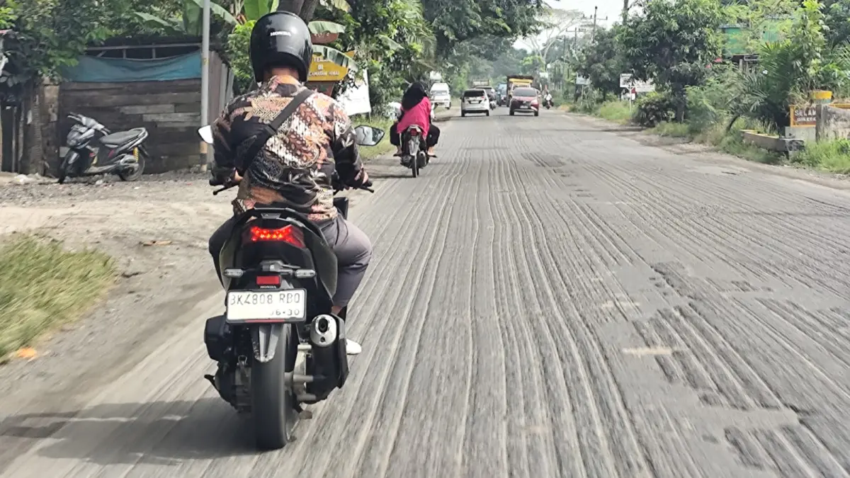 
Pengendara saat melintas jalan nasional yang sudah dikeruk dan belum dilakukan perbaikan di Langkat. (Istimewa/Sumut Pos)