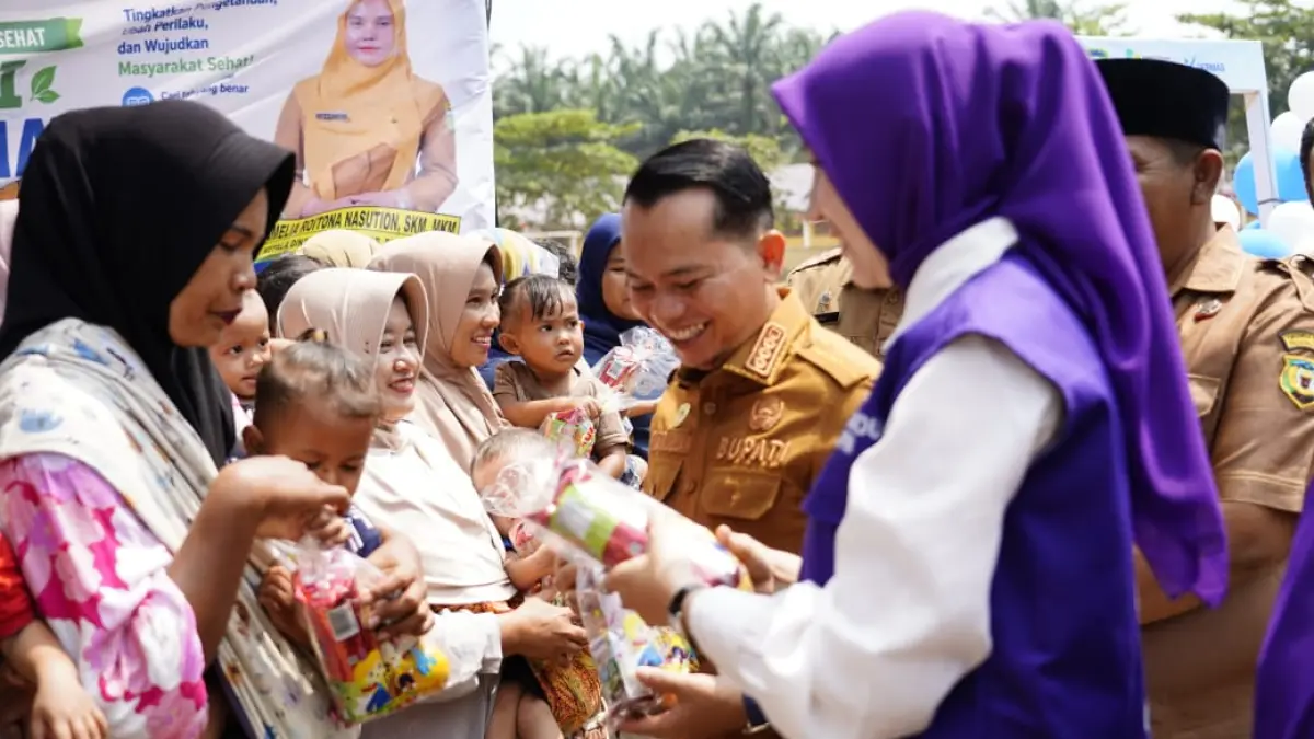 Bupati Padang Lawas Putra Mahkota Alam Hasibuan dan Ketua TP Posyandu Kabupaten Padang Lawas Mahzalena Putra Mahkota Alam Hasibuan saat Penguatan Posyandu dan Arisan PKK di desa Mananti, Senin 24 Agustus 2026. (Mitra Harahap/Sumut Pos)