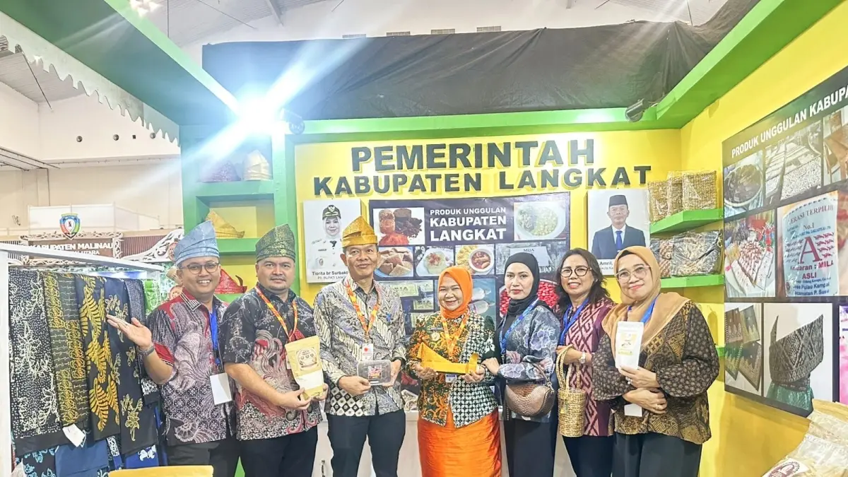 TANJAK: Plt Bupati Langkat, Tiorita br Surbakti saat menunjukkan tanjak yang merupakan produk unggulan yang dipamerkan dalam Apkasi Otonomi Expo di Tangerang. (Dok: Diskominfo Langkat)

