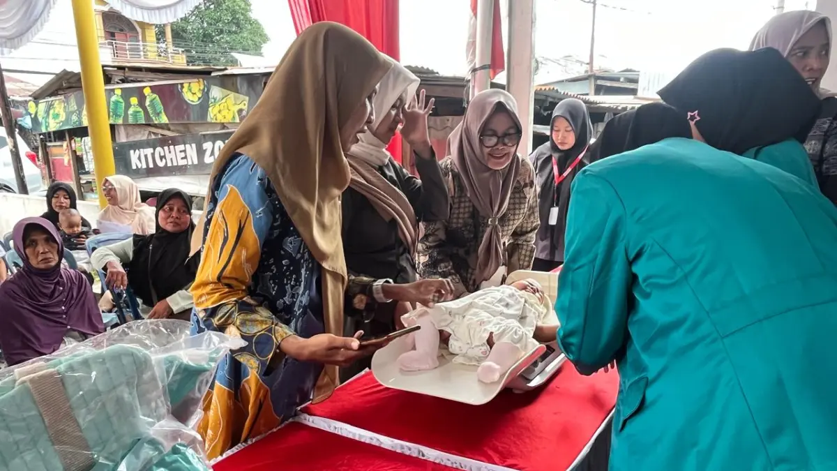 PERIKSA: Bidan saat memeriksa Balita dalam program Sahabat Posyandu Alfamart bersama Sweety di Alfamart Eka Rasmi Medan, Kamis (10/9/2026). (Dok: Alfamart)