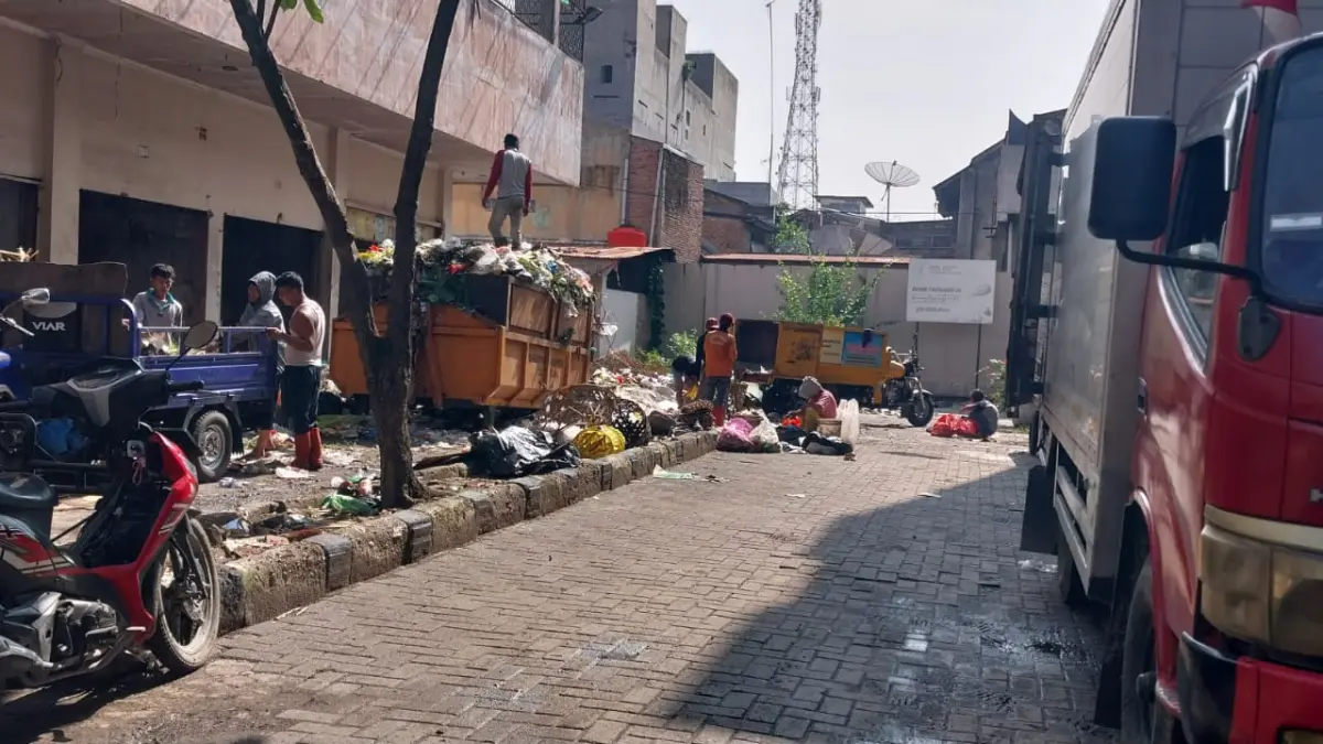 SAMPAH: Kegiatan bongkar muat sampah dari gerobak dimuat ke truk sampah di eks Plaza Delimas. (Dok: warga)